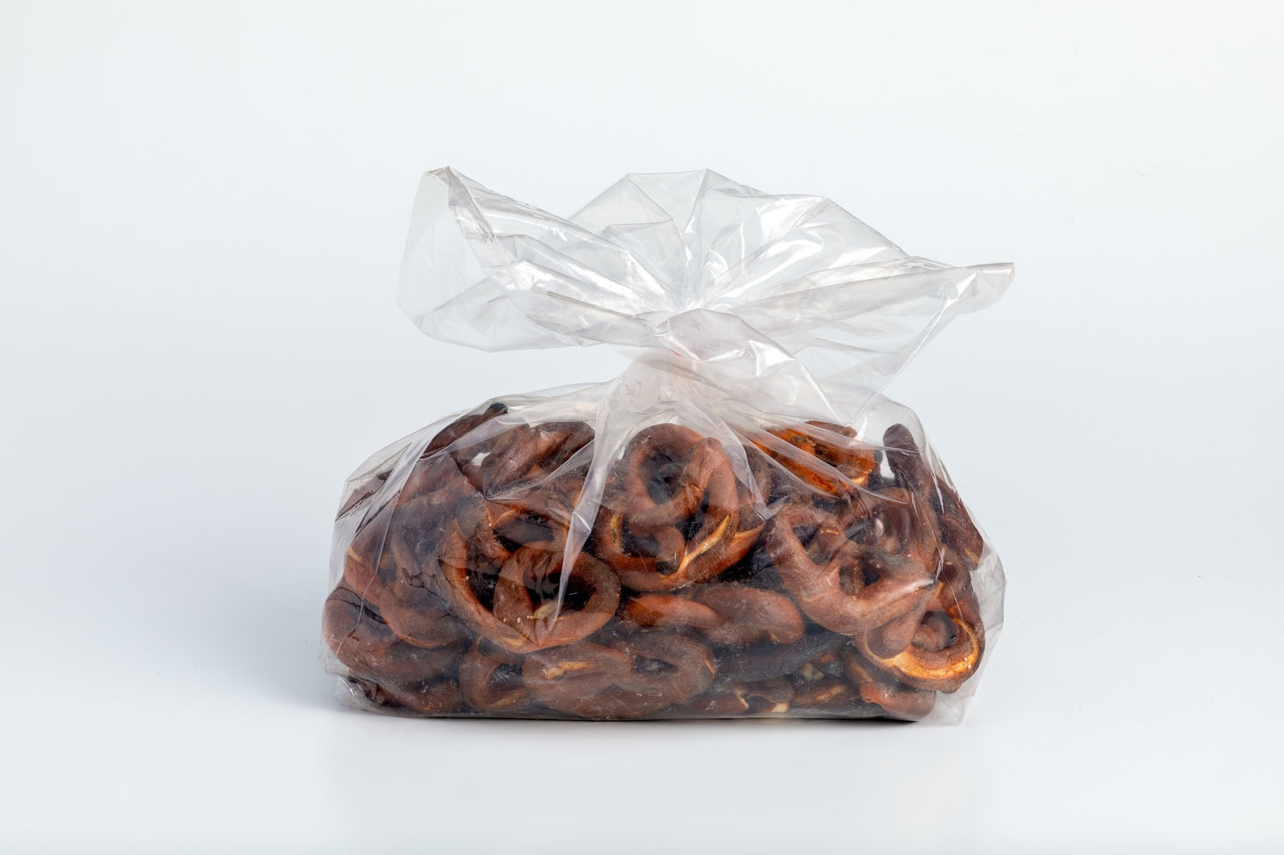 Clear plastic bag filled with dark, extra crispy pretzels.